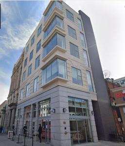 a tall building with people walking in front of it at Prime Hoboken Lofts in Hoboken