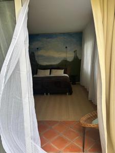 a bedroom with a bed and a painting on the wall at Suite Vigia Jardim in Jardim do Mar