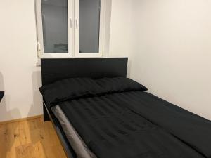 una cama en una habitación con ventana en Cozy City Center Designer Apartment for 10 People, en Wiener Neustadt