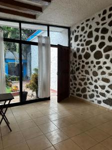 een kamer met glazen schuifdeuren en een stenen muur bij Casa en Cuernavaca Morelos in Cuernavaca