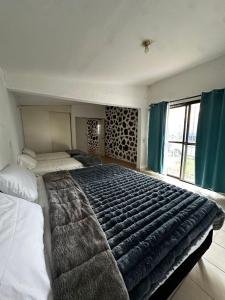 a large bed in a bedroom with a large blanket at Casa en Cuernavaca Morelos in Cuernavaca