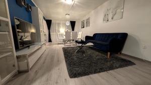 ein Wohnzimmer mit einer blauen Couch und einem Fernseher in der Unterkunft Svedjan Escape Villa in Hedemora