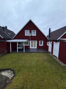 eine rote Scheune mit einer Tischtennisplatte im Hof in der Unterkunft Svedjan Escape Villa in Hedemora