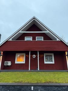 ein rotes Haus mit einem Weihnachtskranz an der Tür in der Unterkunft Svedjan Escape Villa in Hedemora