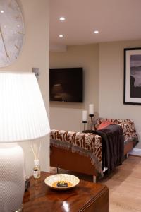 una camera da letto con un letto e un tavolo con una lampada di Garden flat a Bath