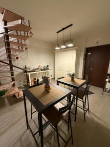 a living room with two tables and a spiral staircase at B&B Arco Trinità in Bari