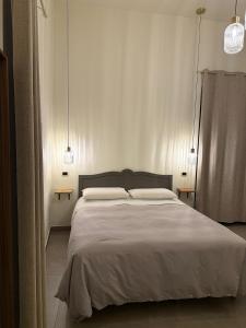a bedroom with a large white bed with two lamps at B&B Arco Trinità in Bari +44 photos