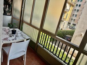 een balkon met een tafel, stoelen en een raam bij Residenza Borgo Trento SUNDAY in Verona