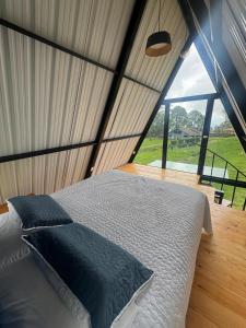 a bed in a room with a large window at Ebenezer Chalet in San Antonio del Tequendama