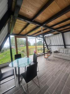 a living room with a glass table and chairs at Ebenezer Chalet in San Antonio del Tequendama