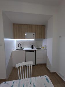 een kleine keuken met witte kasten en een spoelbak bij Luna del este in Peñíscola