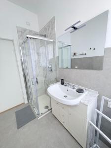 een witte badkamer met douche en wastafel bij Oltre le mura in Montefalco +10 foto's