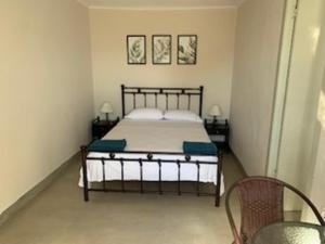 a bedroom with a bed and two chairs in it at Vero's Seaview Studio in Lefki
