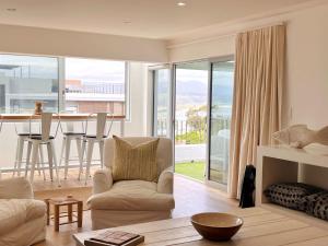 a living room with a couch and a table with a view at Kana Vista in Plettenberg Bay