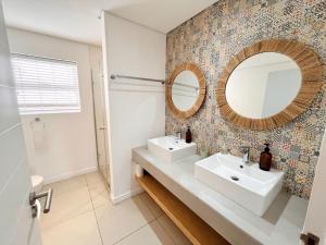 a bathroom with two sinks and a mirror at Kana Vista in Plettenberg Bay +23 photos