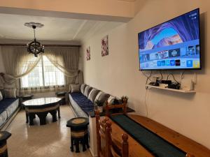 丹吉尔1 Minute from Beach, Sea View Apartment in Tangier city centre的客厅里有一张沙发，墙上有一台电视