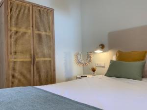a bedroom with a white bed and a wooden cabinet at Luxury Beachfront "Felicità" Sea View 6 Guests in Arenales del Sol