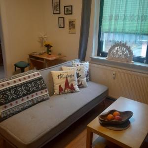 a couch with pillows and a bowl of fruit on a table at Taurasteinblick in Burgstaedt