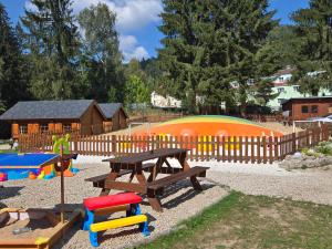 a playground with a picnic table and a wooden fence at Horská CHATA U ŠPIČÁKU in Josefuv dul