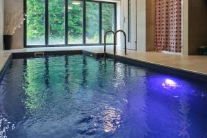 a large swimming pool with blue water in a building at Horská CHATA U ŠPIČÁKU in Josefuv dul