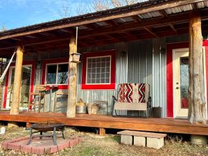 a porch of a house with a bench and a chair at The Barn House in Eureka Springs