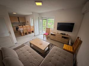 a living room with a couch and a flat screen tv at White Villa Blažuj in Blažuj
