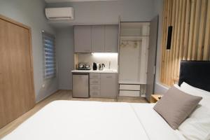 普雷韦扎Preveza Suitestay Apartments Dodonis 28的一间带一张白色大床的卧室和一间厨房 更多14张照片