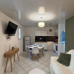 ein Wohnzimmer und eine Küche mit einem Tisch und Stühlen in der Unterkunft Maison de vacances 3 étoiles - Sous les Pins in Ozillac