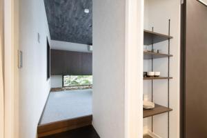 a hallway of a house with white walls and wooden shelves at Casa Stay Kokura 1 - Vacation STAY 18791v in Kitakyushu