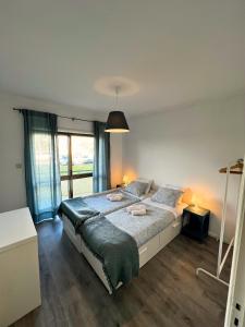 a bedroom with a large bed and a large window at Naval Beach Apartment in Azurara +58 photos