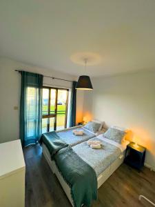 ein Schlafzimmer mit einem großen Bett mit einem großen Fenster in der Unterkunft Naval Beach Apartment in Azurara