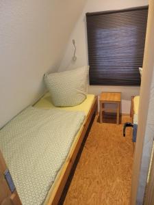 una piccola stanza con un letto e una finestra di Glücklich am Strand - Ruhe im Kiefernwald mit Terrasse & Hund willkommen a Trassenheide