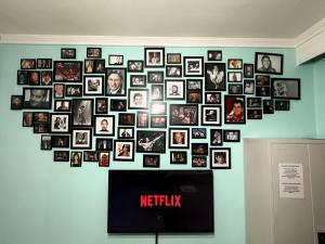 a wall of pictures on a wall with a tv at Folia studio Φωλιά στούντιο - myHomee in Xanthi +4 photos