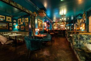 a bar with blue walls and tables and chairs at Caboose in Salisbury