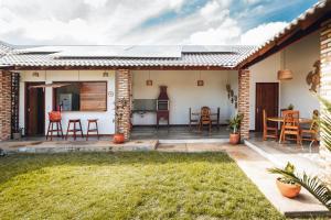 a patio with chairs and a kitchen in a house at Villa Chalés - térreo in Barra Grande