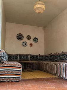 a living room with a couch and plates on the wall at Your Peaceful Spot in Essaouira