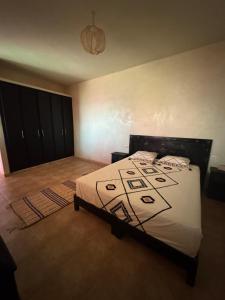 a bedroom with a bed with a black and white comforter at Your Peaceful Spot in Essaouira