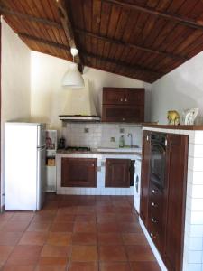 a kitchen with wooden cabinets and a white refrigerator at Private house with car park at nemi lake  +15 photos
