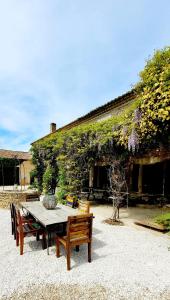 een houten tafel en banken voor een gebouw bij Mas La Pomarede in Robion en Luberon
