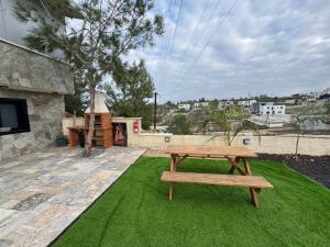 a wooden picnic table sitting on a green lawn at רויאל דליה in Dāliyat el Karmil