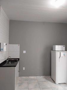 KITNET ELVIS PRESLEY - Largo do Machado في ريو دي جانيرو: مطبخ مع ثلاجة بيضاء في الغرفة