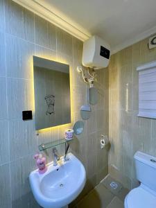 a bathroom with a sink and a toilet and a mirror at Stylish, spacious 1BR on Admiralty Lekki in Maroko