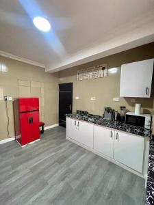 a kitchen with a red refrigerator in a room at Stylish, spacious 1BR on Admiralty Lekki in Maroko