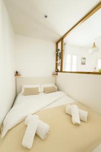 een slaapkamer met 2 bedden en handdoeken op de vloer bij L'impasse Japandi in Libourne