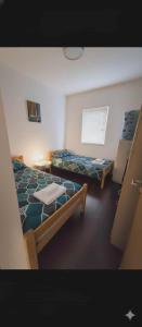 Una habitación con dos camas y una mesa dentro. en Apartman Boki, en Trebinje