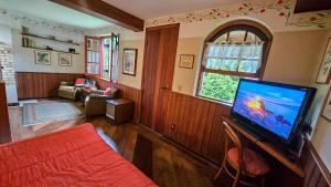 een woonkamer met een grote flatscreen-tv bij Estalagem Entardecer da Serra in Monte Verde