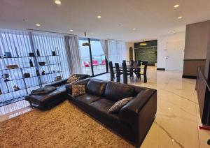 un soggiorno con divano in pelle e una sala da pranzo di Sky High 15 - Luxury Penthouse with Panoramic View a Beer Sheva Altre 5 foto