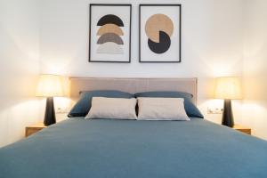a bedroom with a blue bed with two lamps at Boutique Apartment with Sun Terrace & Sea Views in Torremolinos