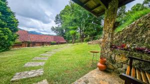 een binnenplaats met een stenen muur en een stenen pad bij Estalagem Entardecer da Serra in Monte Verde