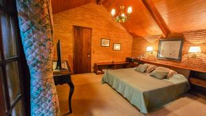 een slaapkamer met een bed in een kamer bij Estalagem Entardecer da Serra in Monte Verde